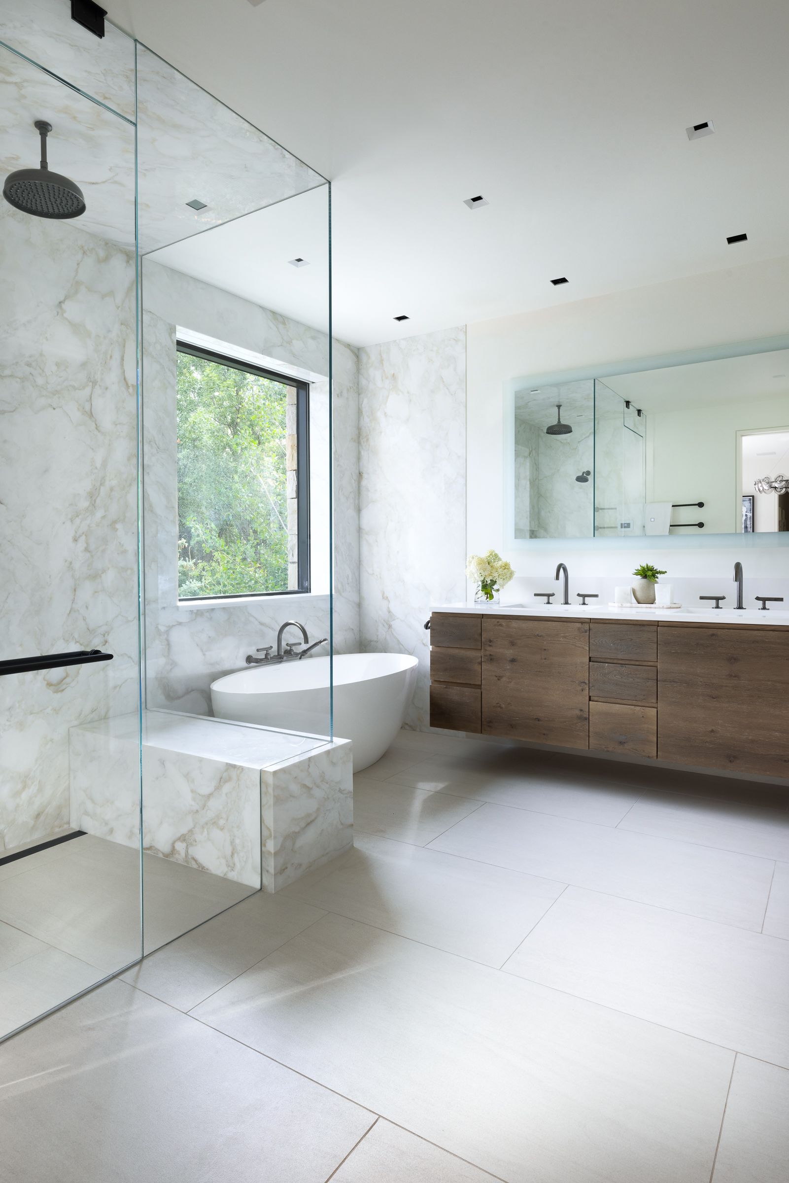 A bathroom with two sinks , a tub and a walk in shower.