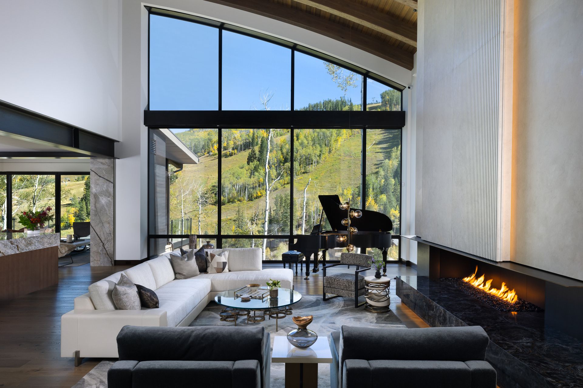 A living room with a fireplace , couch , chairs and a piano.