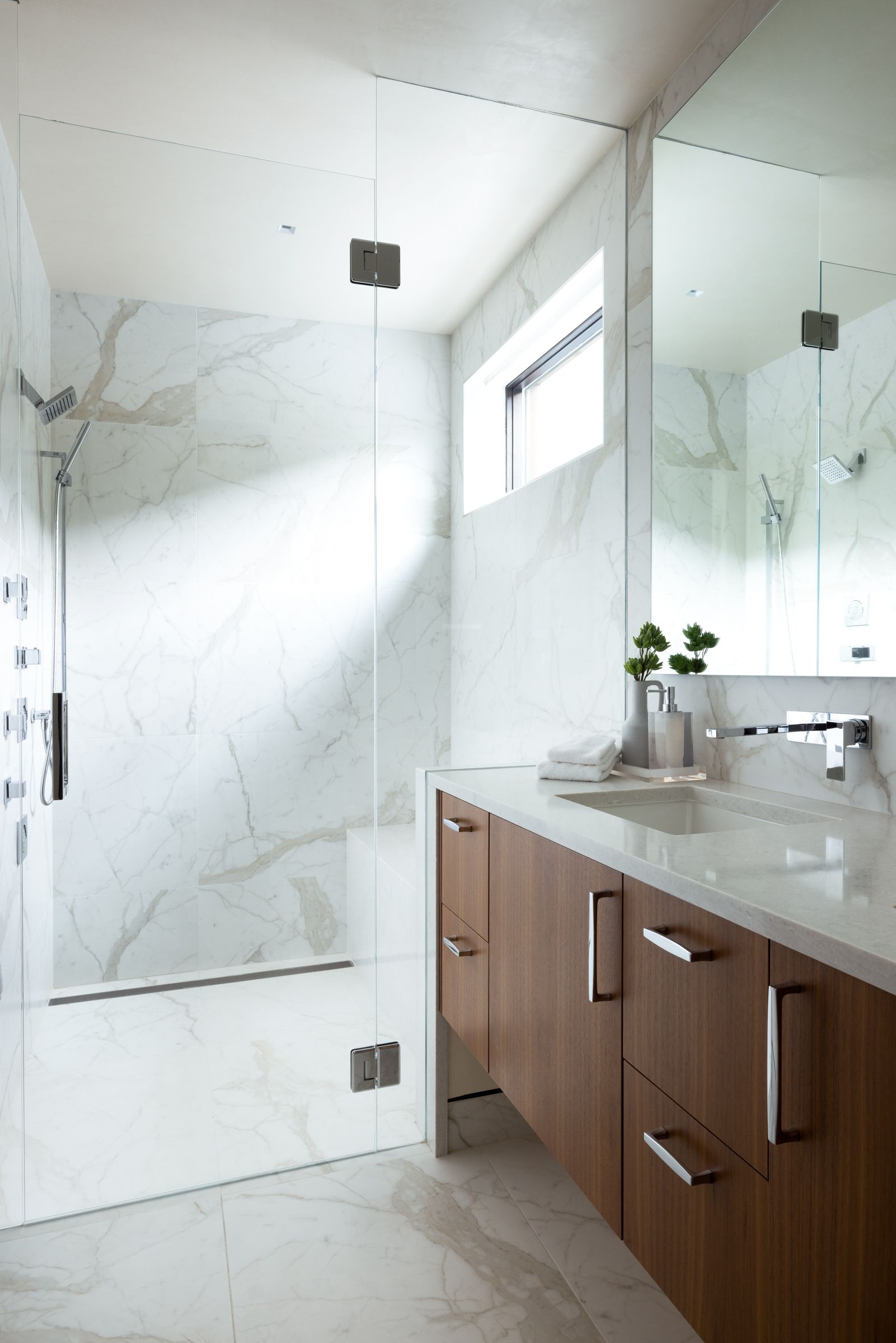 A bathroom with a sink and a walk in shower