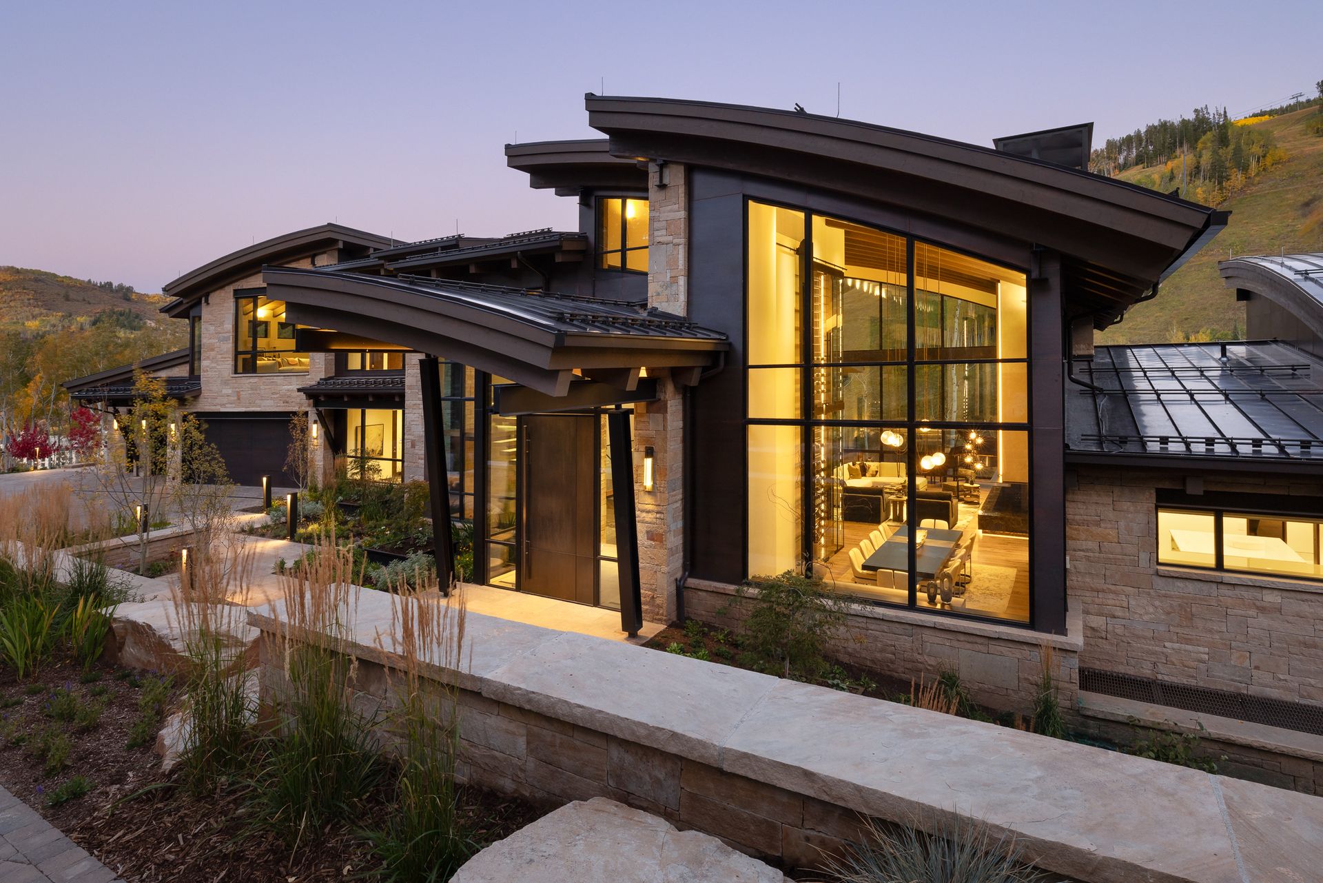 A large house with a lot of windows is sitting on top of a hill.