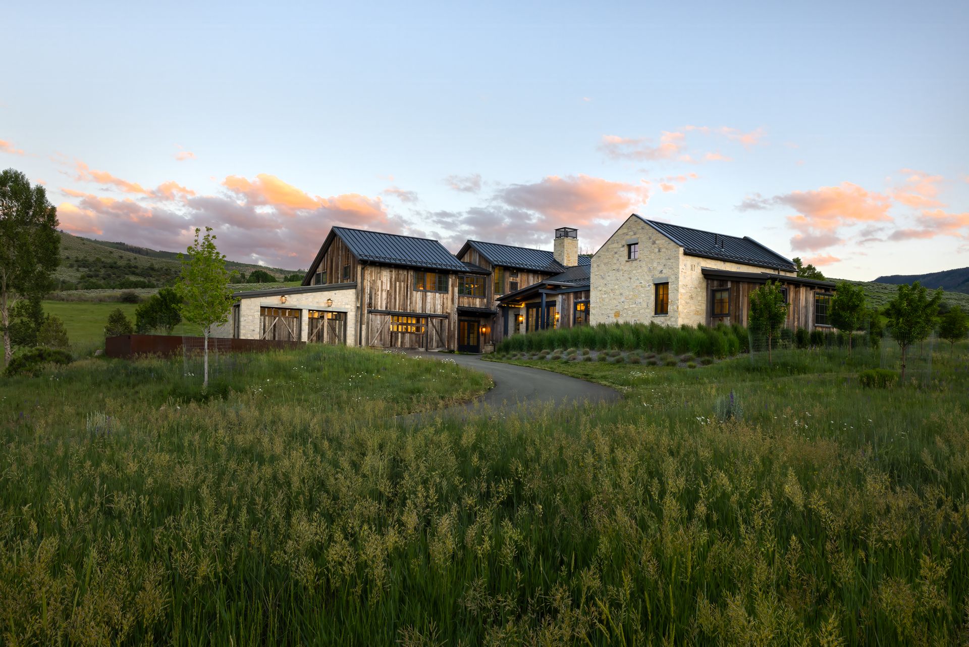 A large house is sitting in the middle of a grassy field.