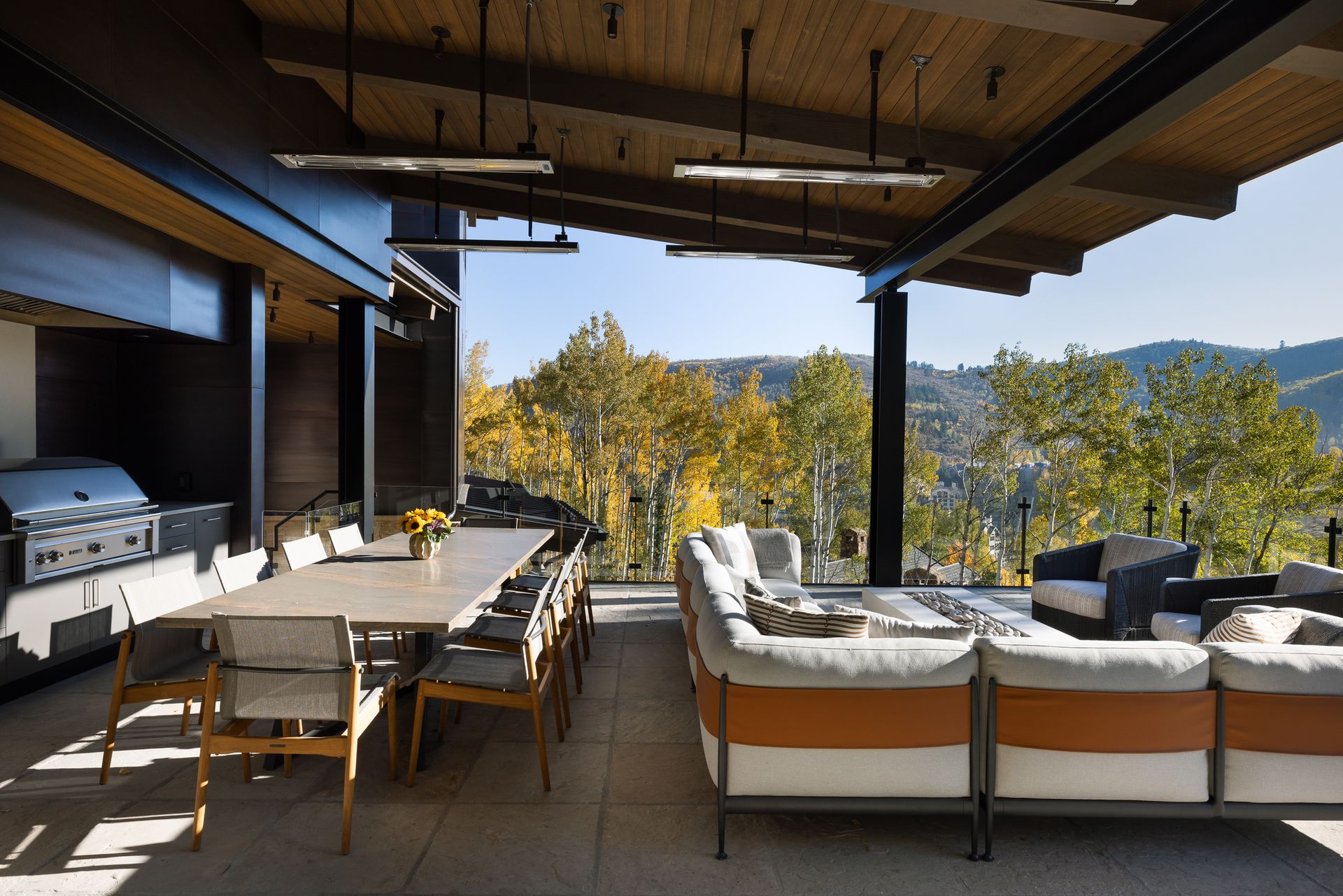 A large patio with a table , chairs , and a grill.