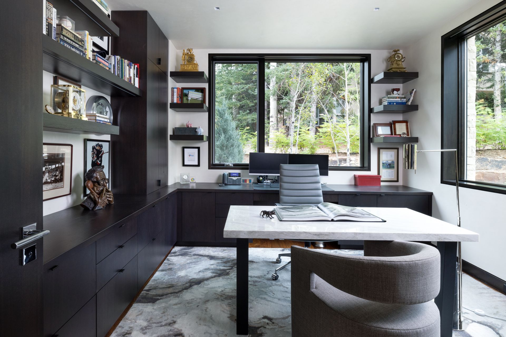 A home office with a desk and chair and a large window.