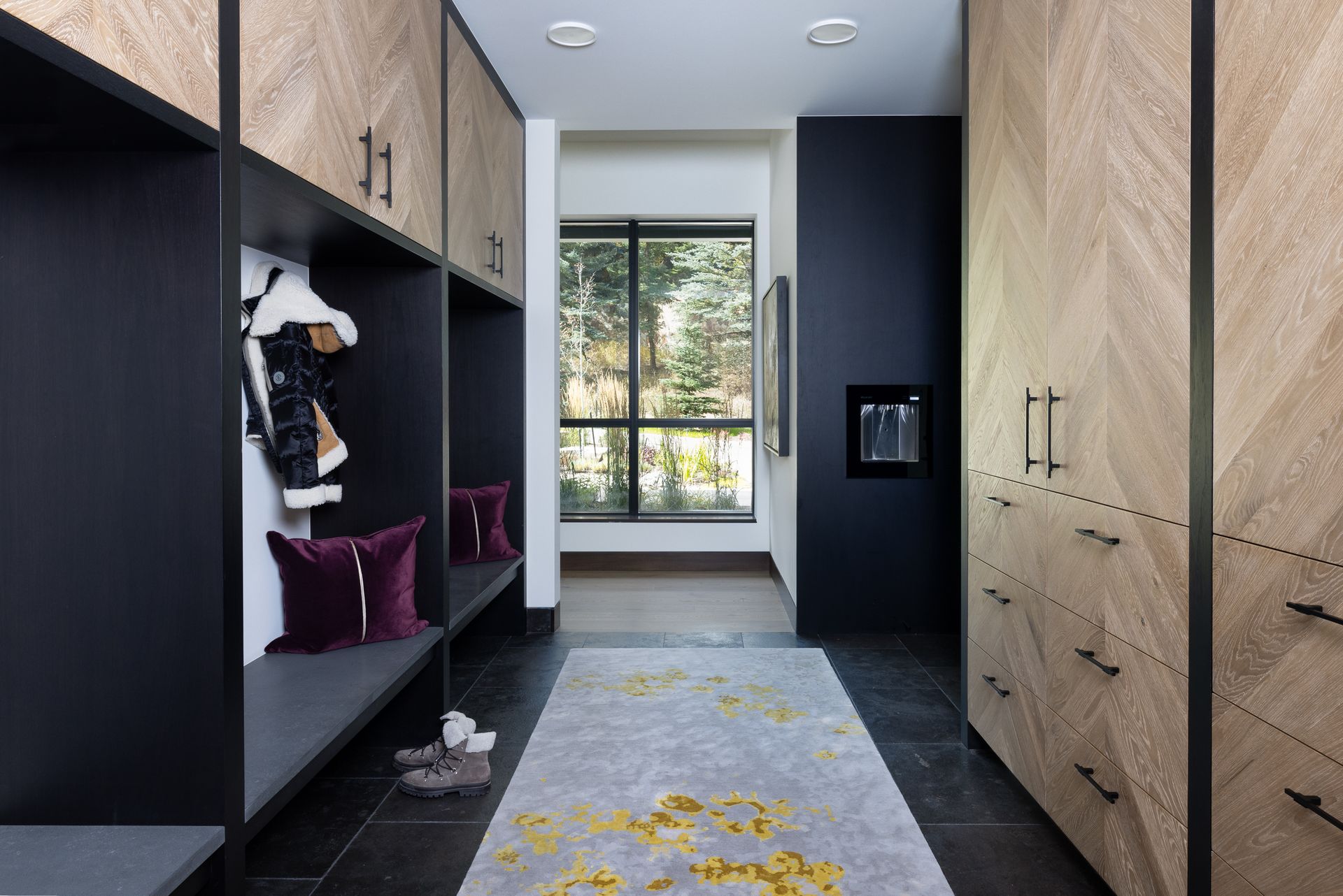 A hallway with lots of cabinets and drawers and a rug.