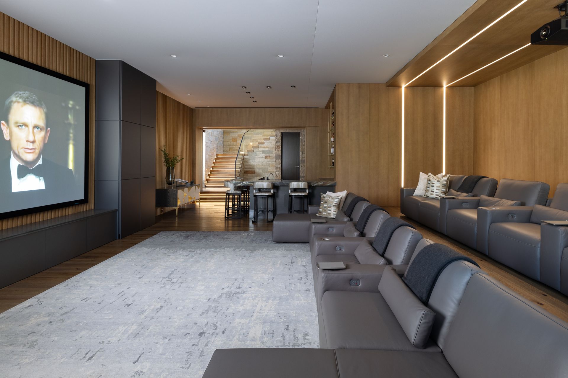 A living room with a couch , chairs and a large screen.