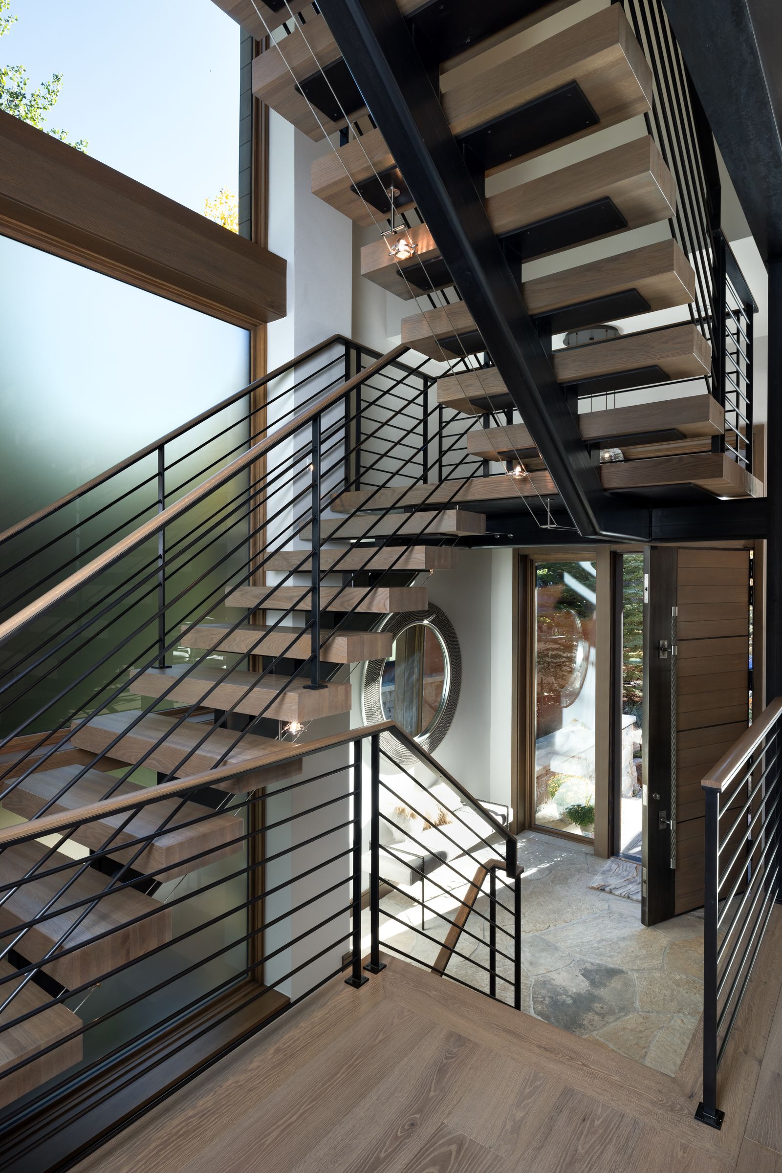 A wooden staircase with a metal railing in a house