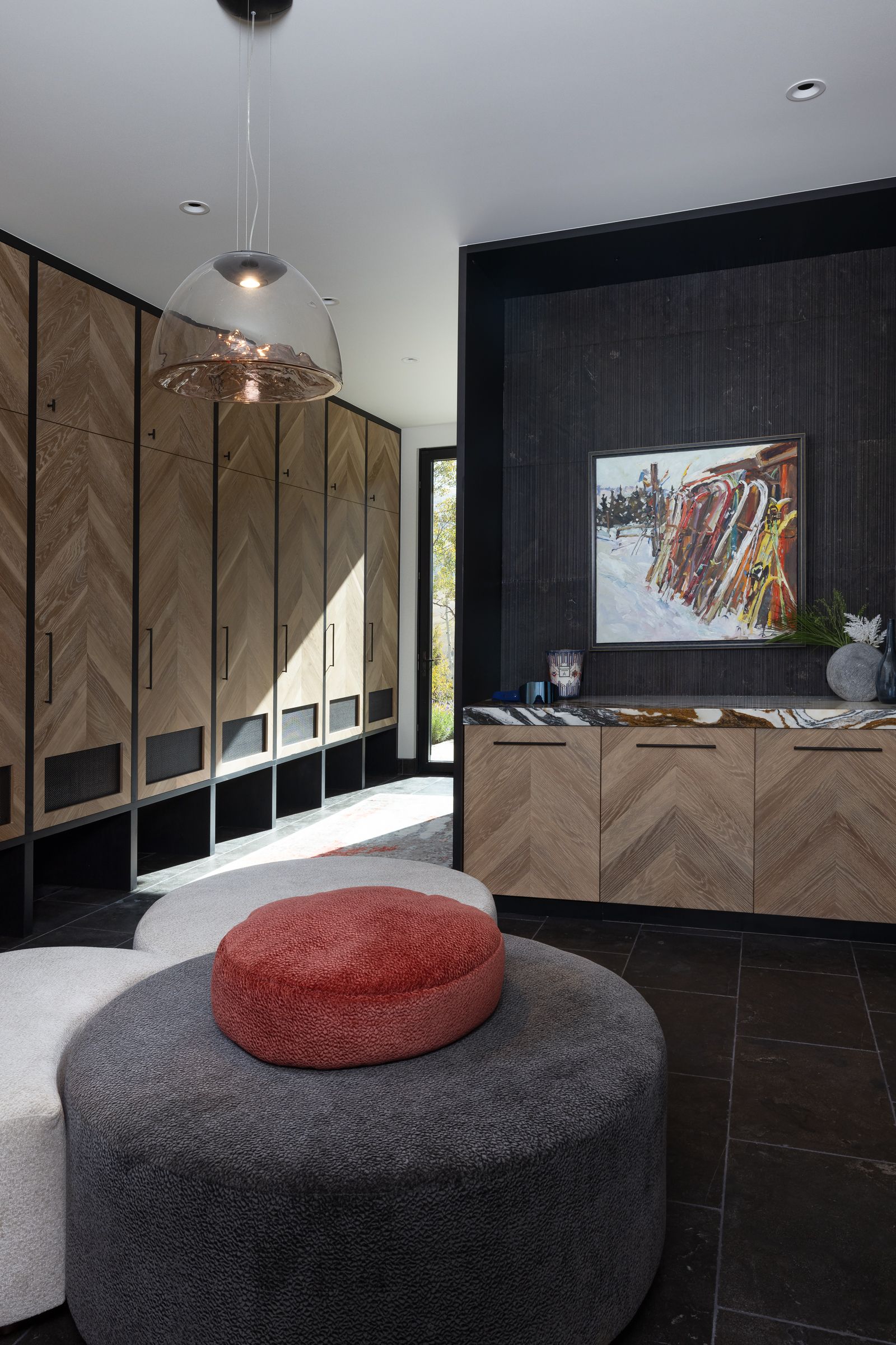 A living room with a round ottoman and a painting on the wall.