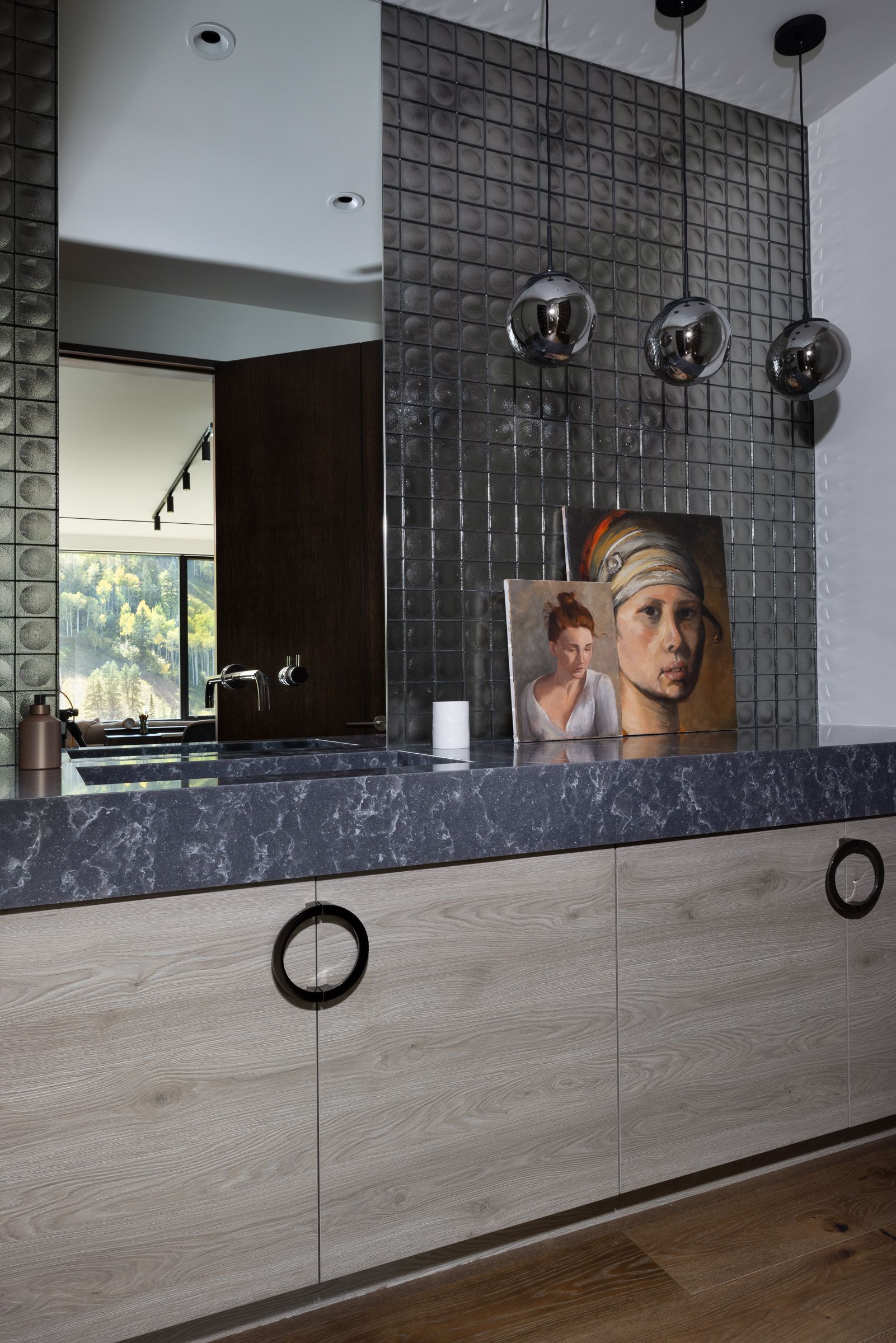 A painting of a woman with a pearl earring is on a counter in a bathroom.