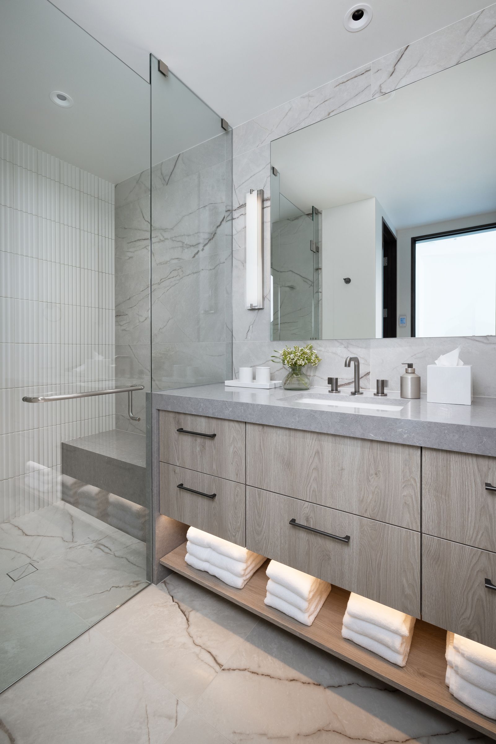 A bathroom with two sinks and a walk in shower
