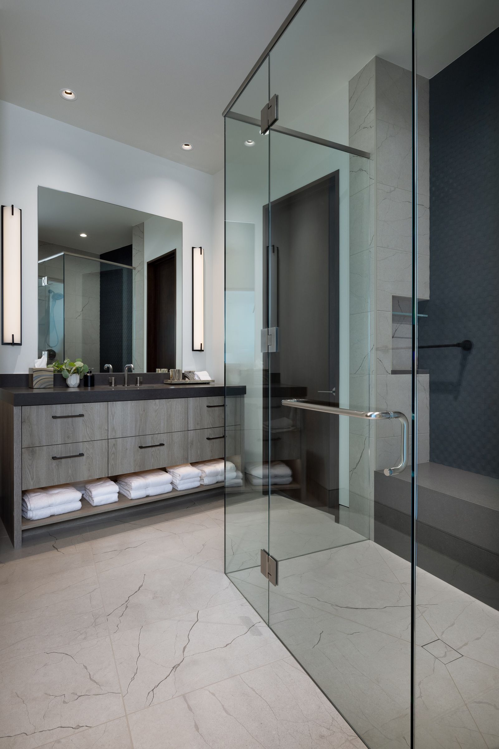 A bathroom with two sinks and a walk in shower.