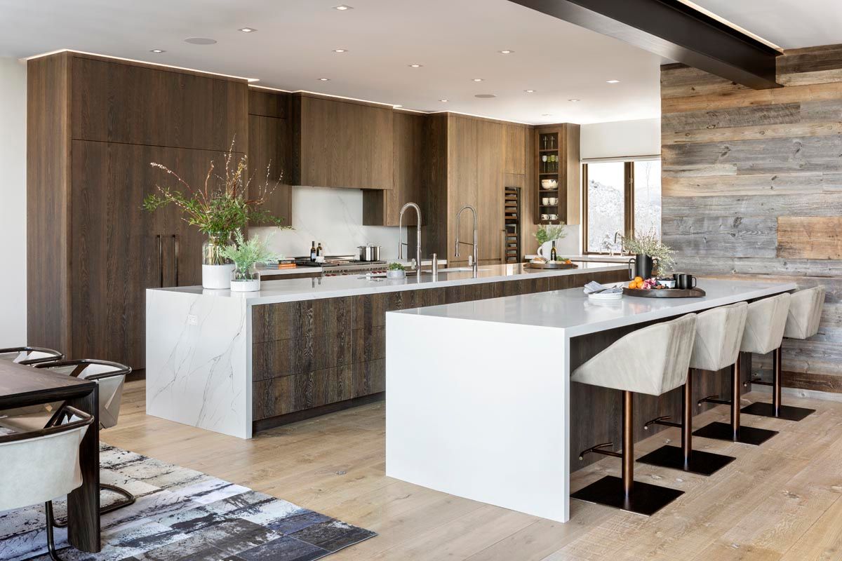 A kitchen with a large island in the middle of it and wooden cabinets.