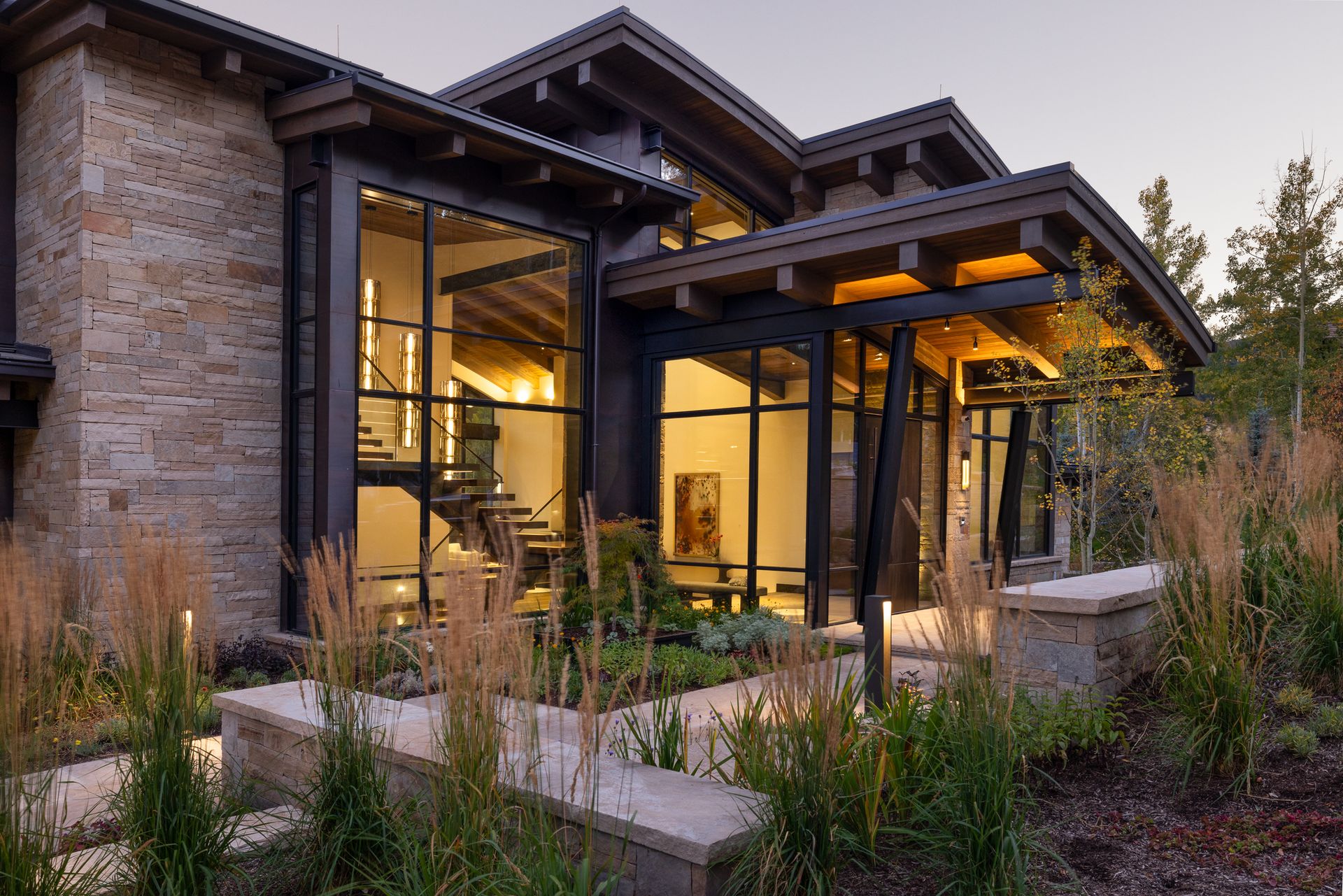 A large house with a lot of windows is surrounded by trees and bushes.