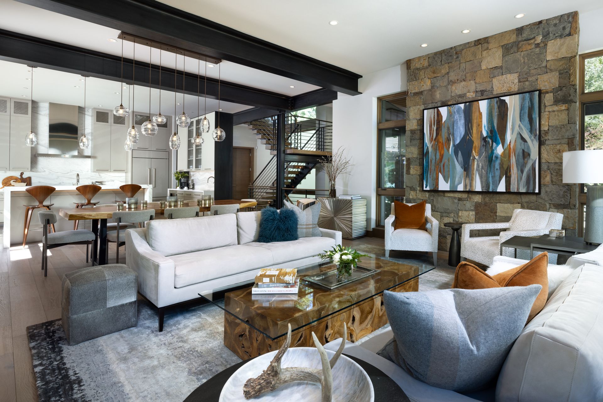 A living room with a couch , chairs , and a coffee table.