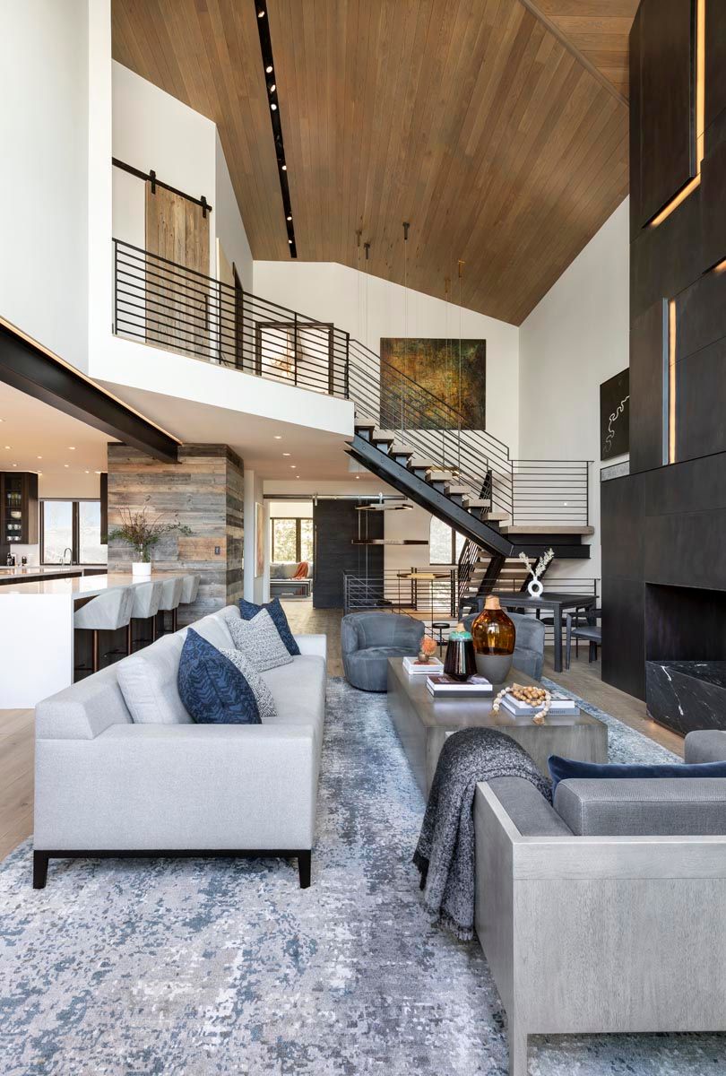 A living room filled with furniture and a staircase leading to the second floor.