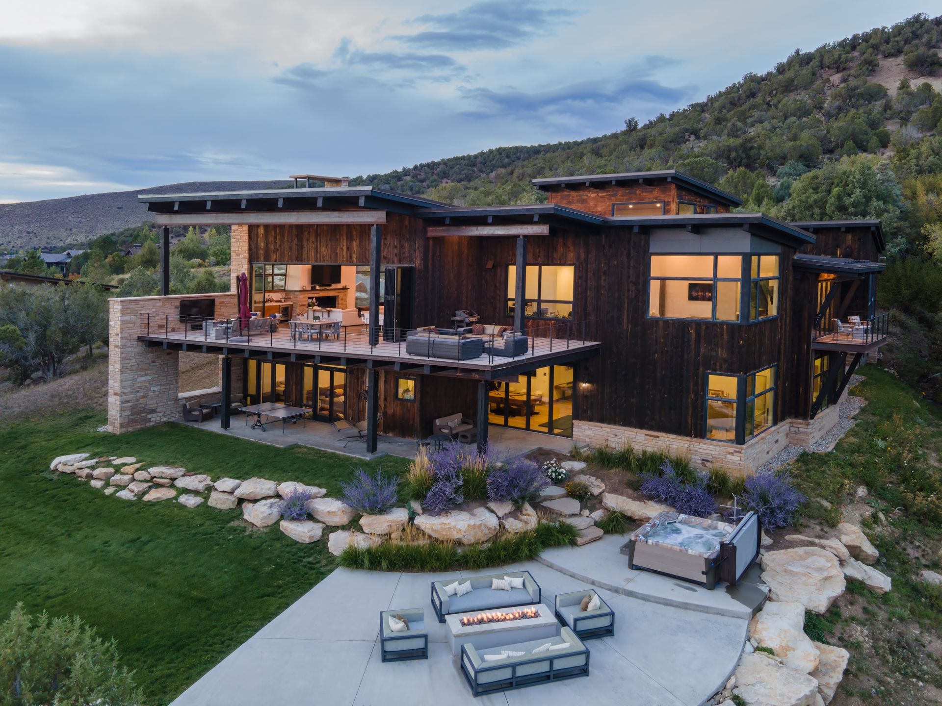An aerial view of a large house with a fire pit in the backyard.
