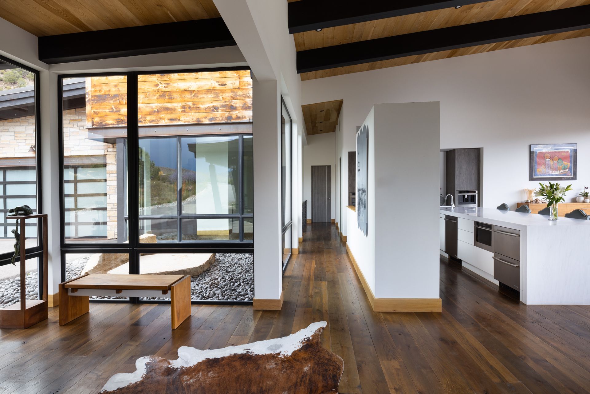 A living room in a house with a cowhide rug on the floor.