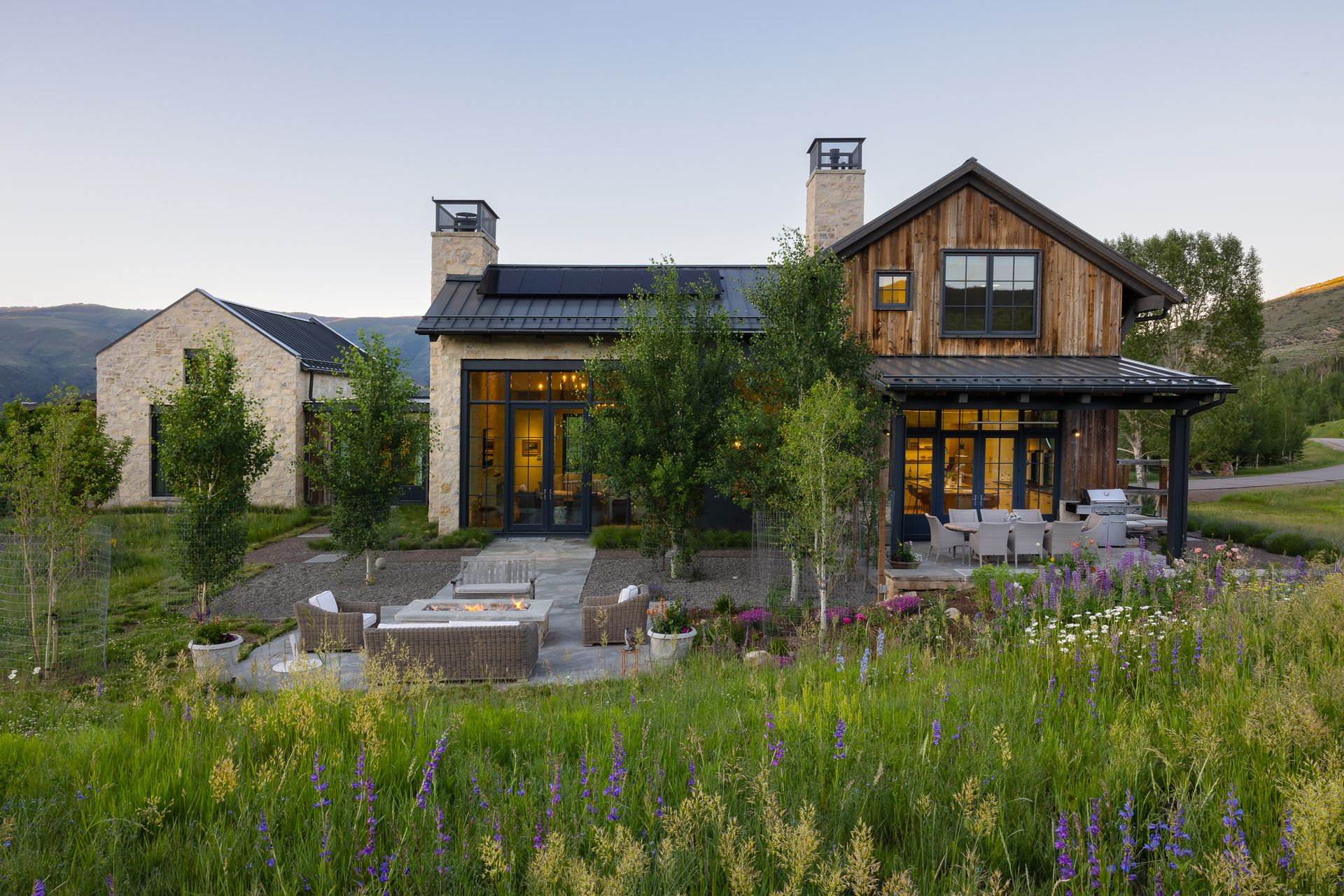 A large house is sitting in the middle of a grassy field.