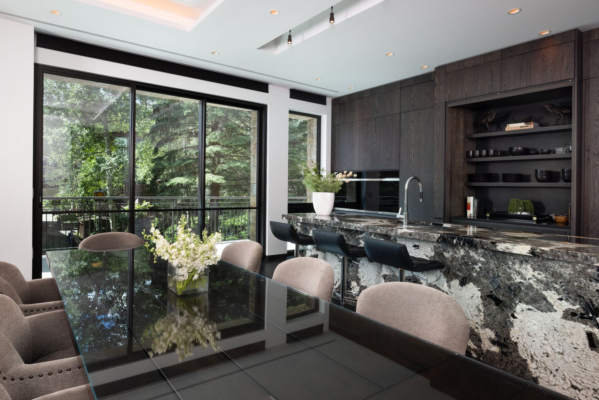 A kitchen with a table and chairs and a large window