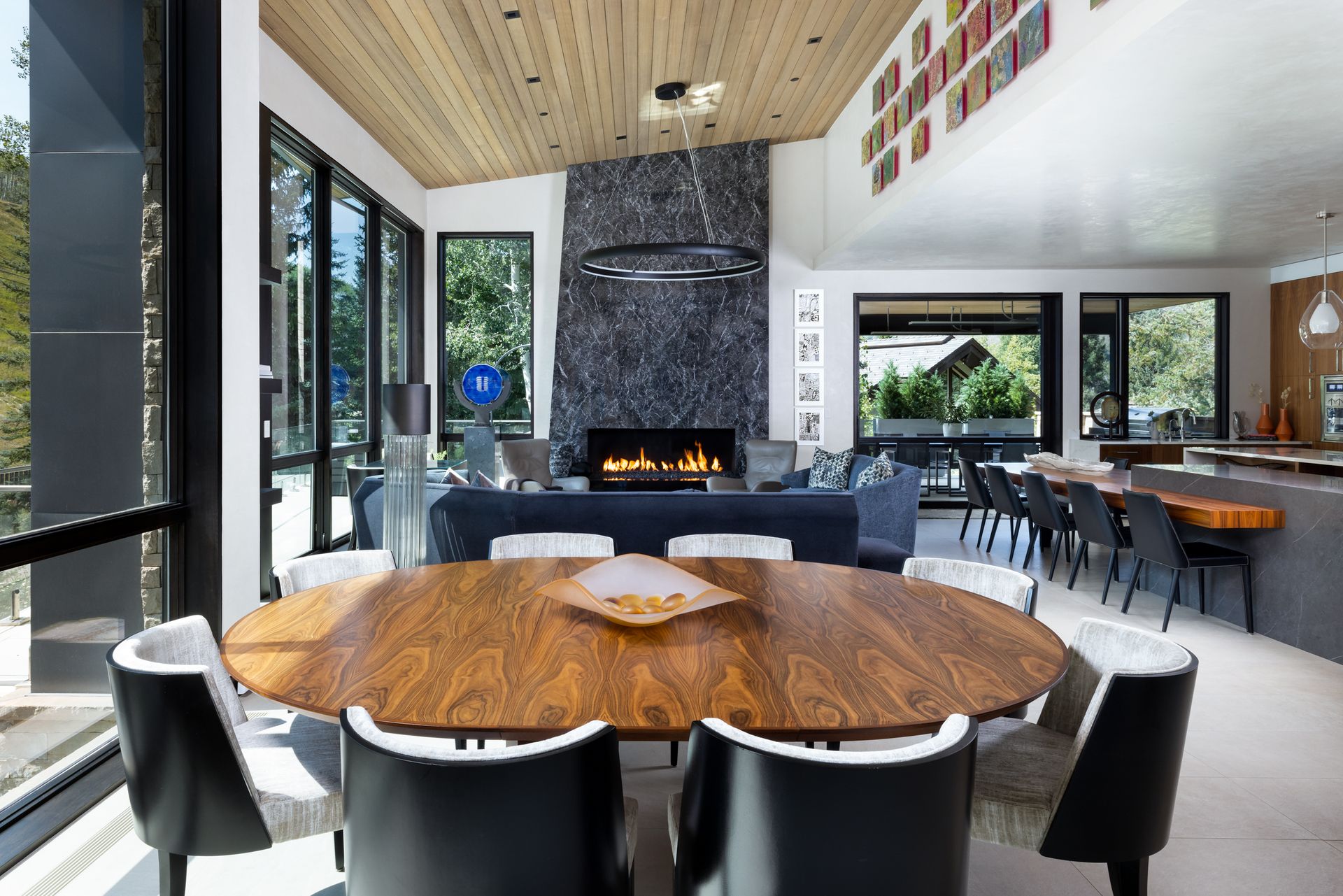 A dining room with a round table and chairs and a fireplace.