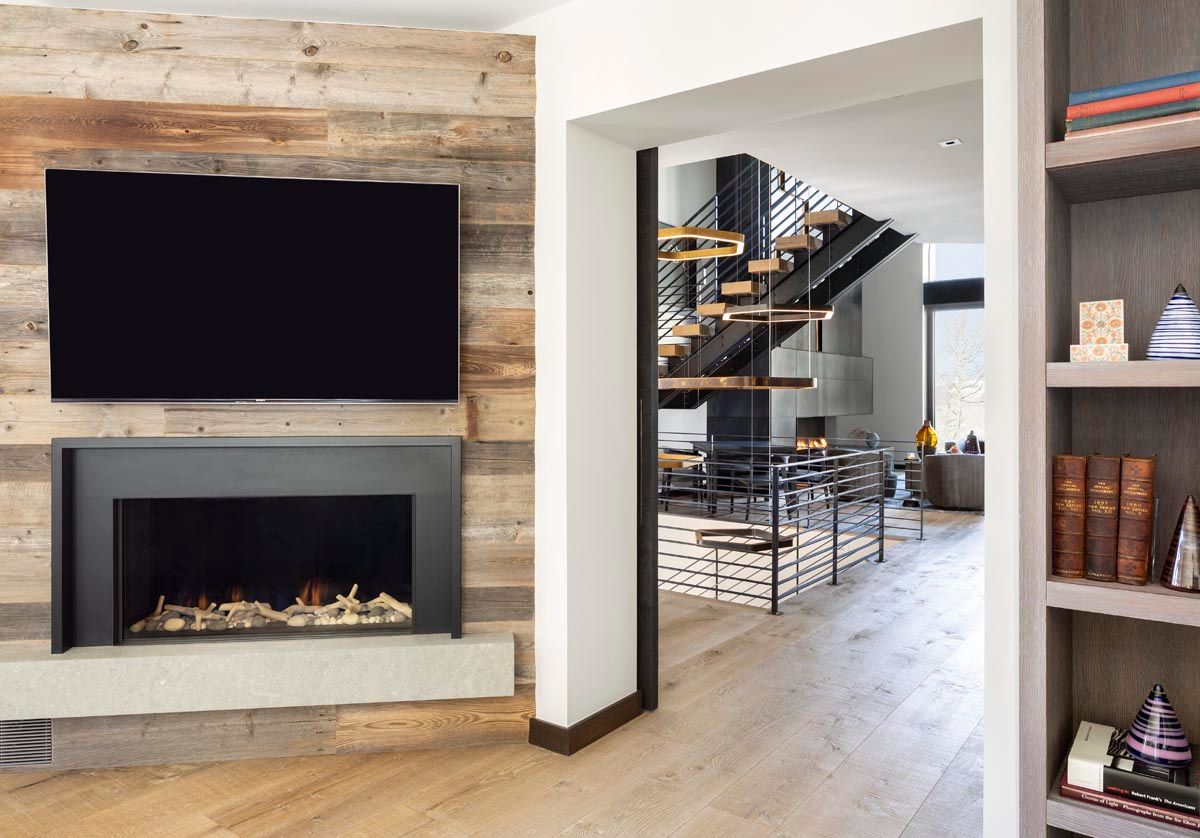 A living room with a fireplace and a flat screen tv on the wall.