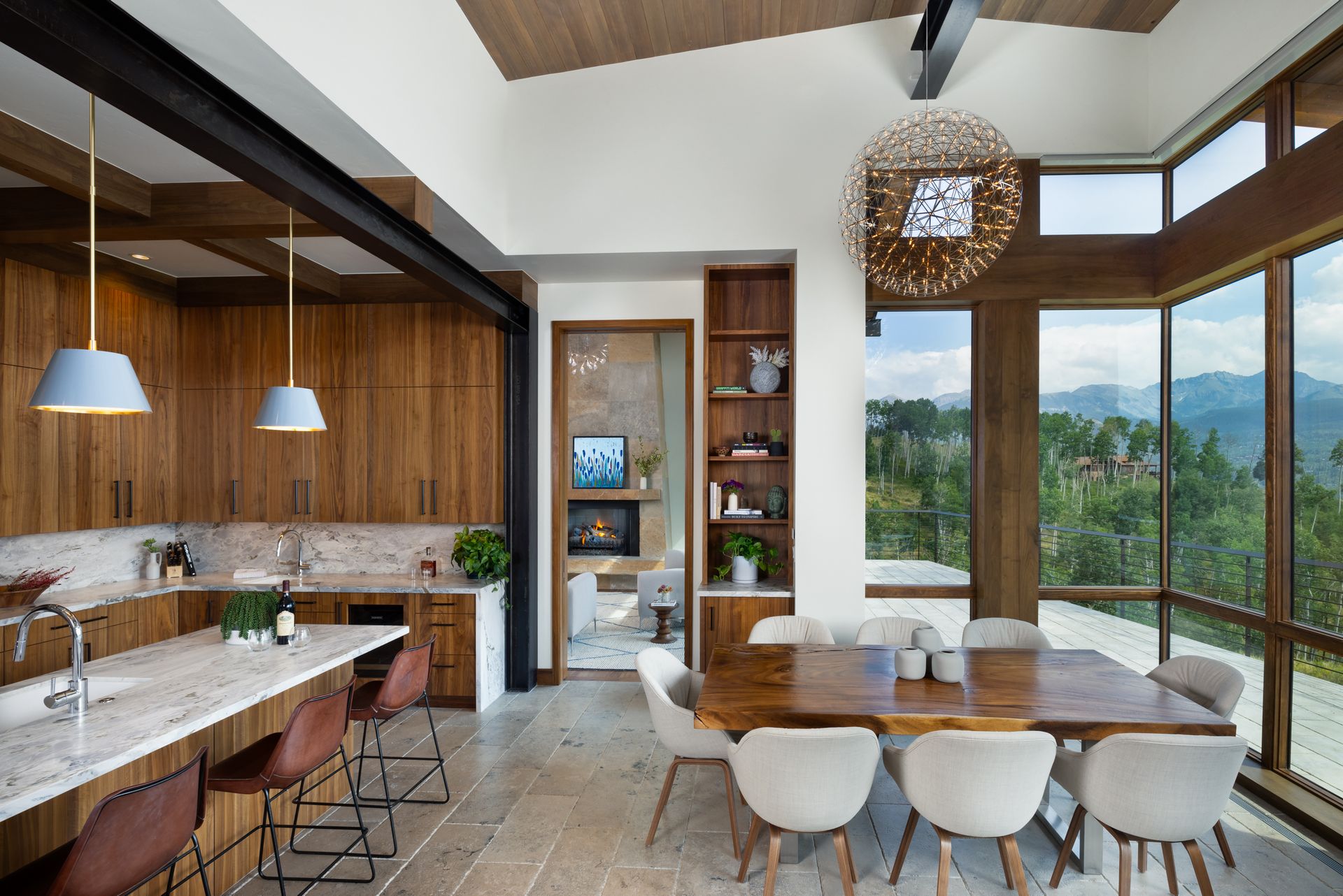 A kitchen and dining room in a house with a large table and chairs.