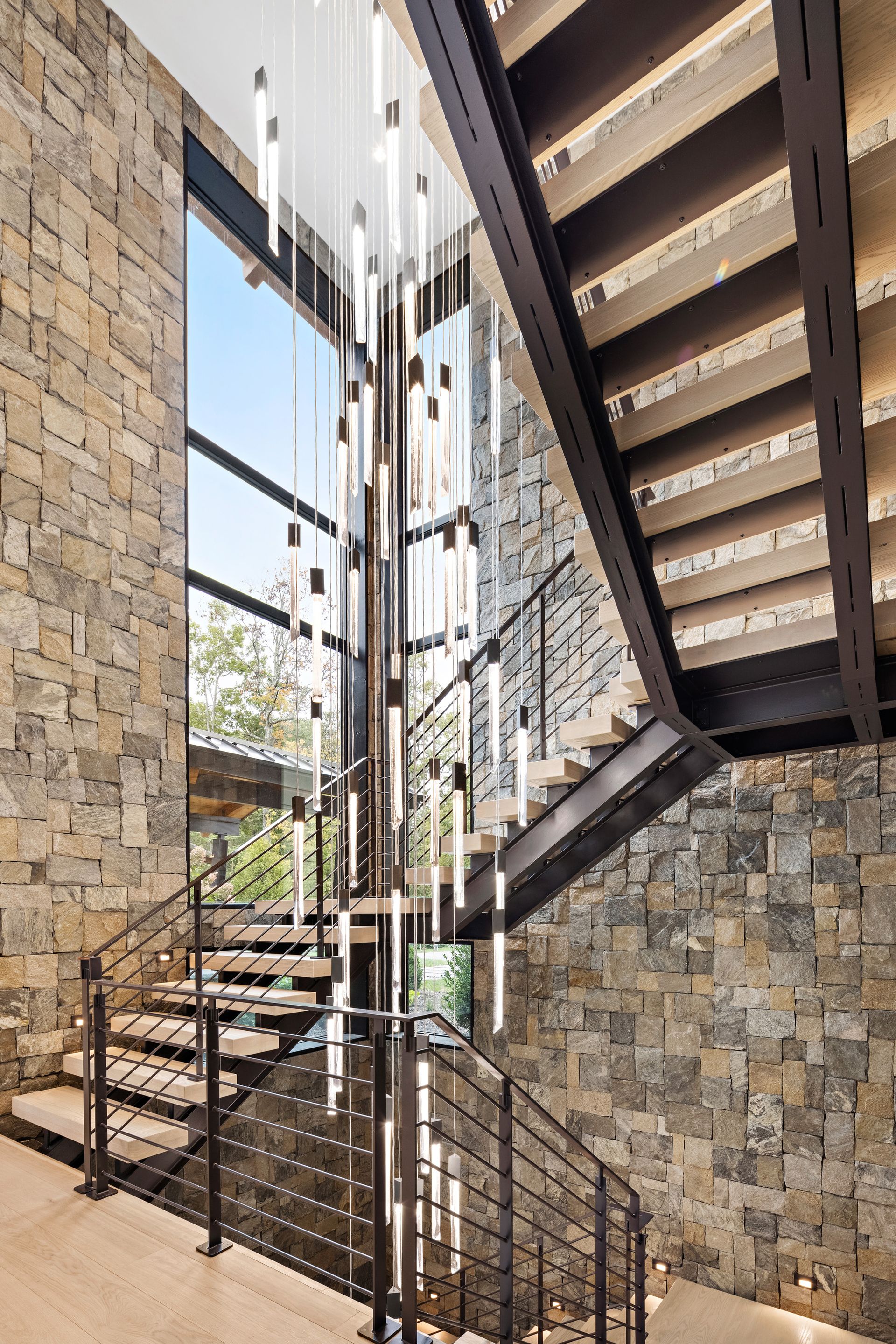 A staircase with a chandelier hanging from the ceiling in a house.