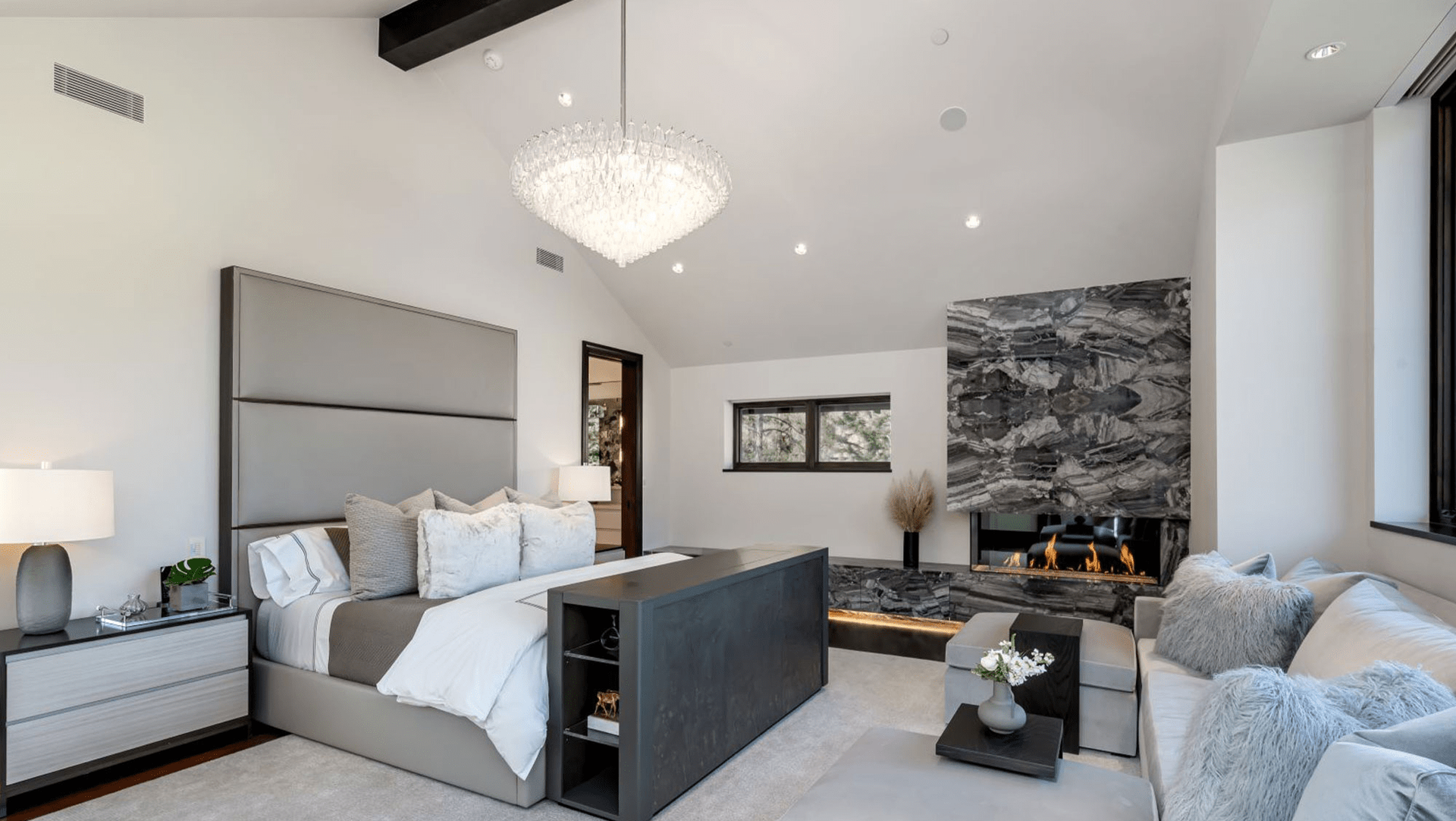 A bedroom with a large bed and a fireplace.