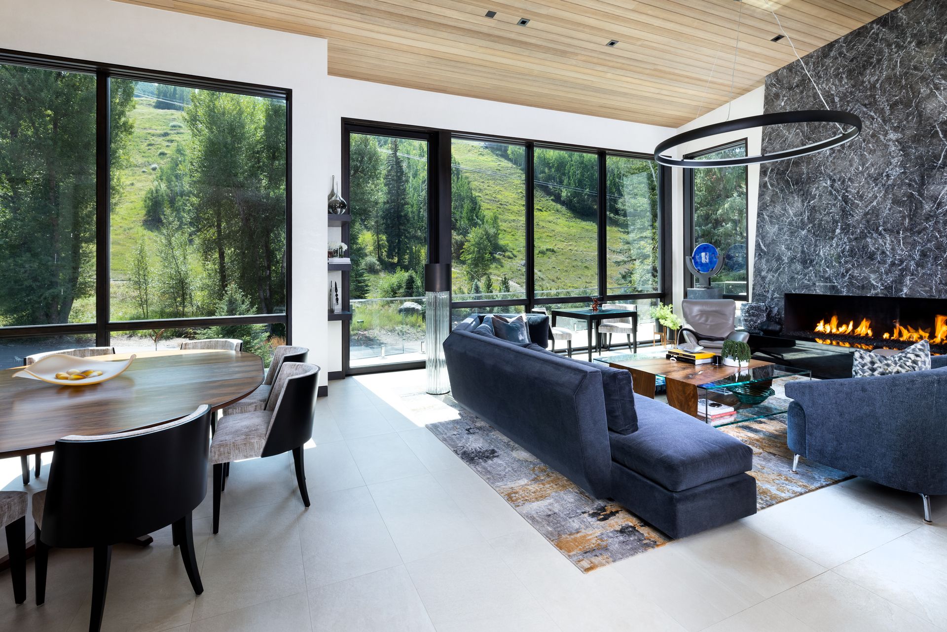 A living room with a fireplace , couch , table and chairs.