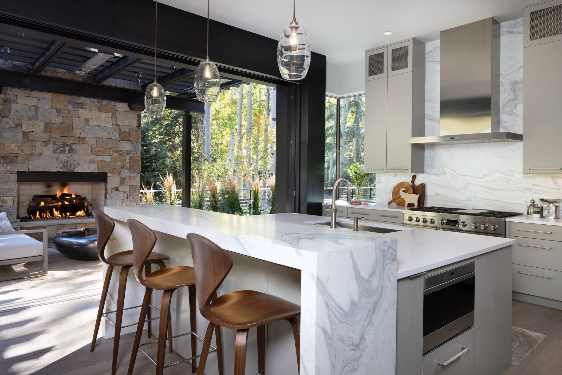 A kitchen with a large island and stools and a fireplace
