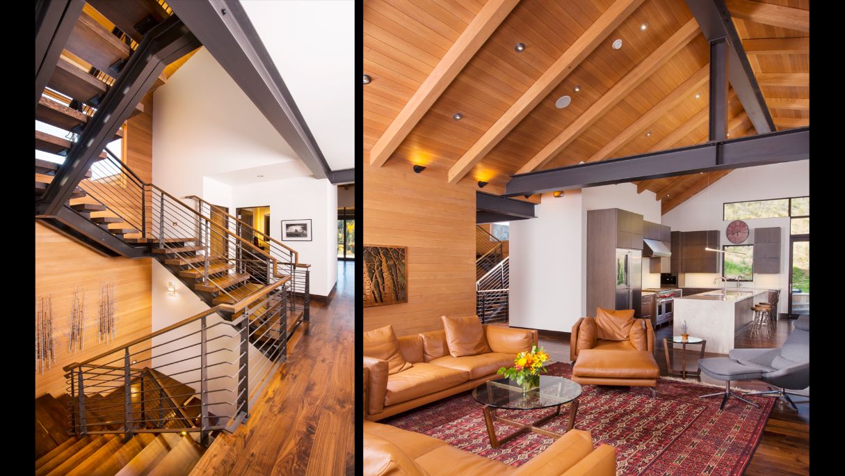 A large house is sitting on top of a hill with mountains in the background.