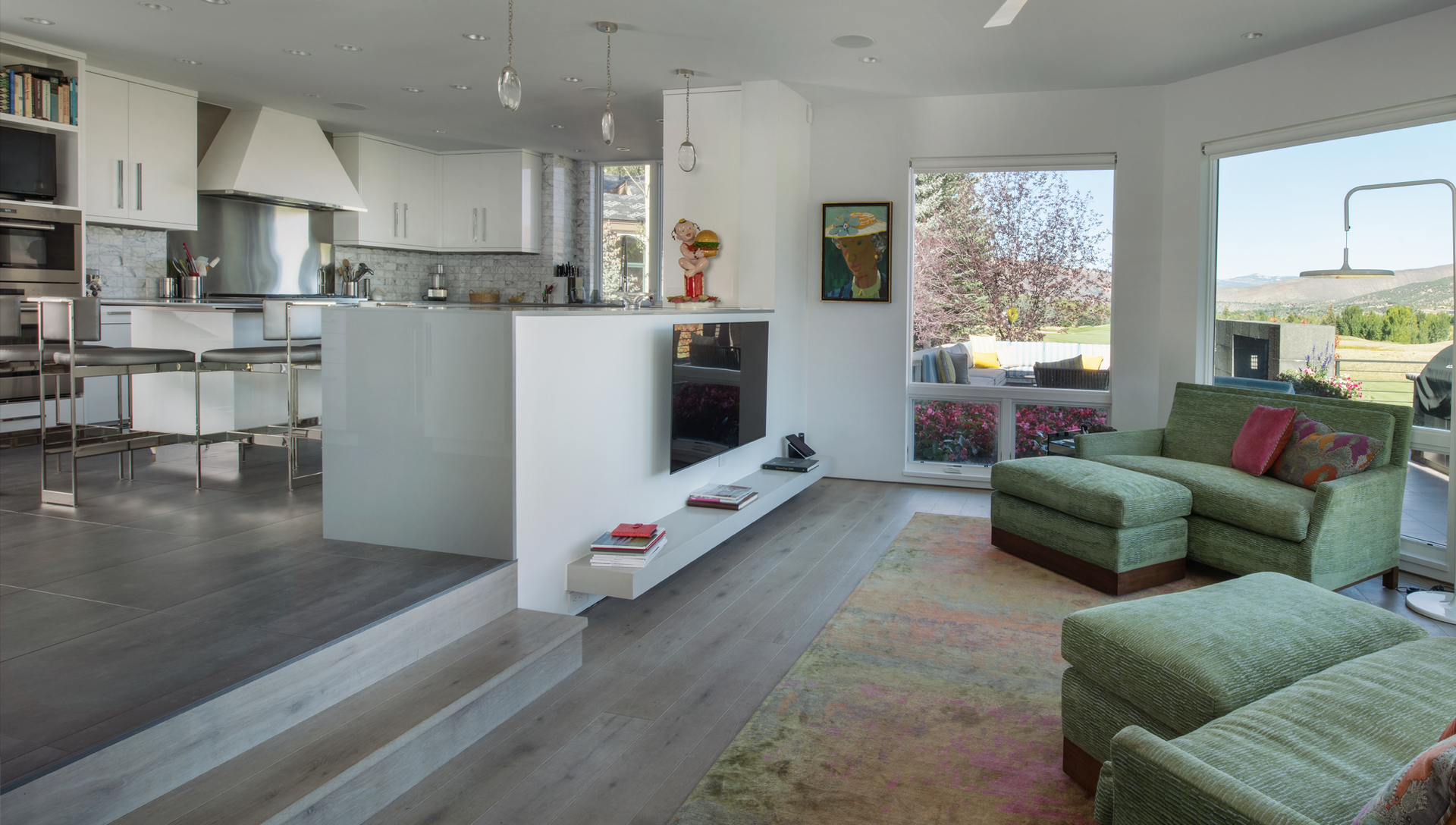 A living room with a couch , ottoman , and television.