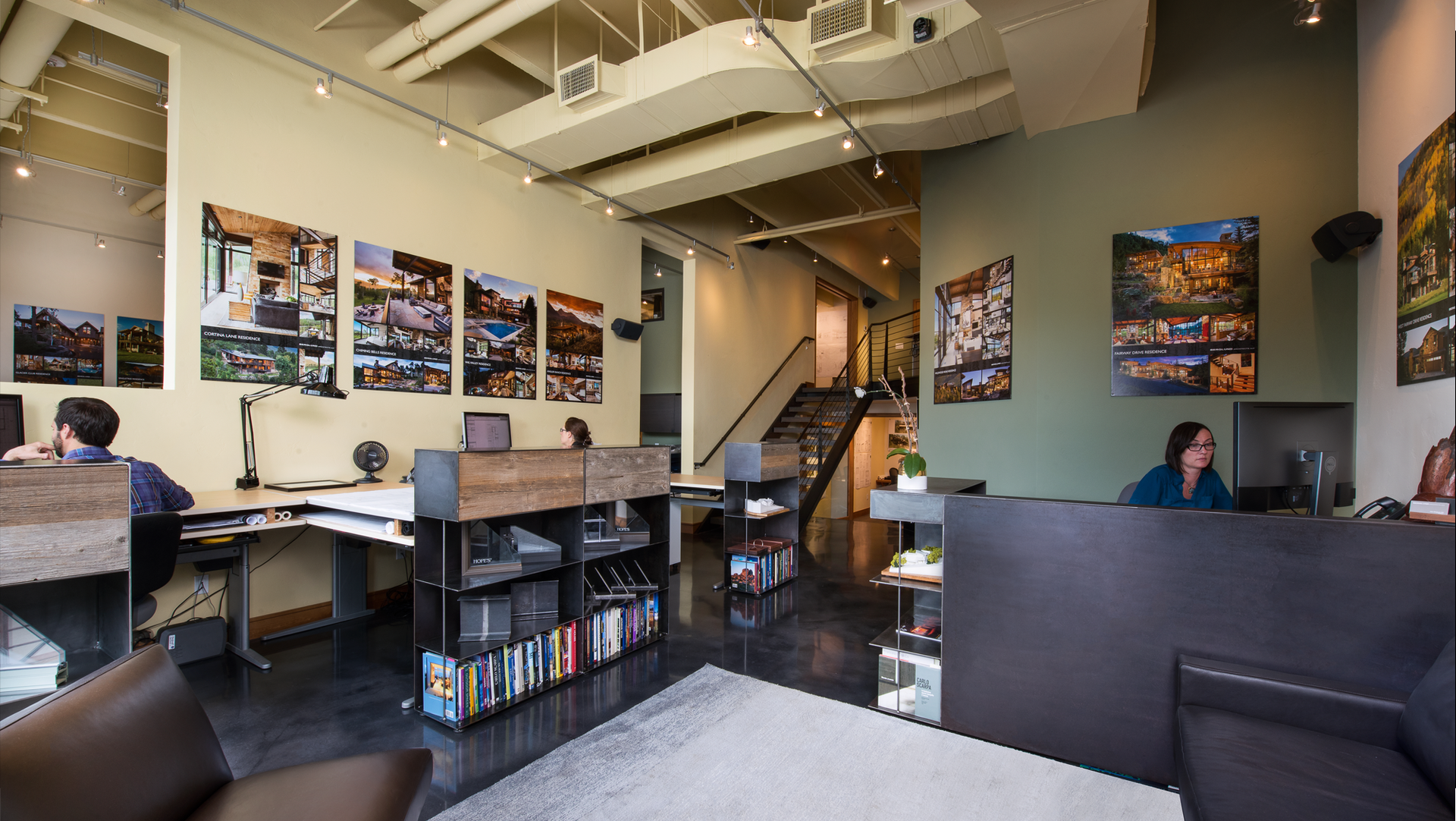 A group of people are sitting at desks in an office
