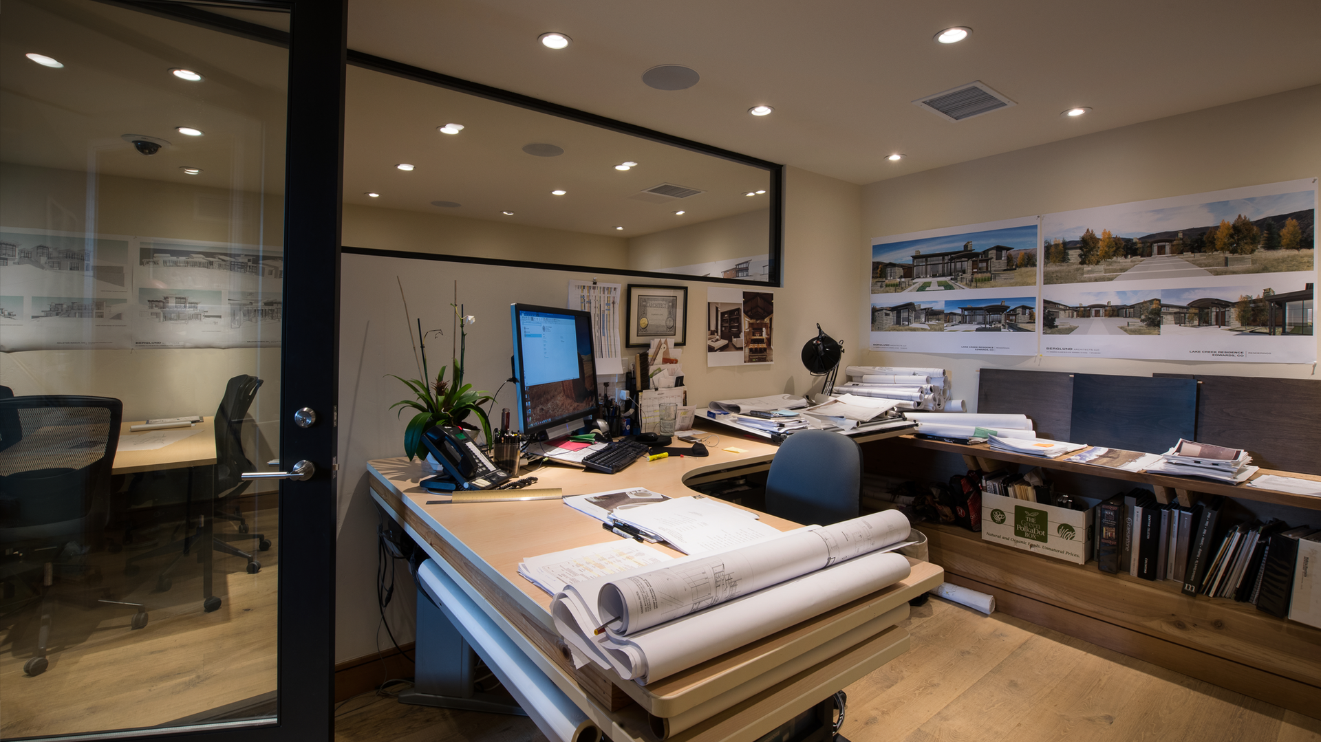 A room with a desk , chairs , and a computer.