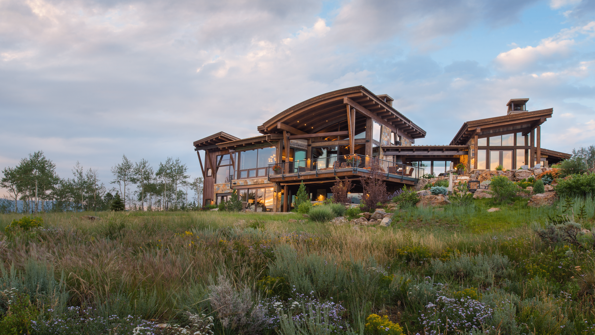 A large house is sitting in the middle of a grassy field.