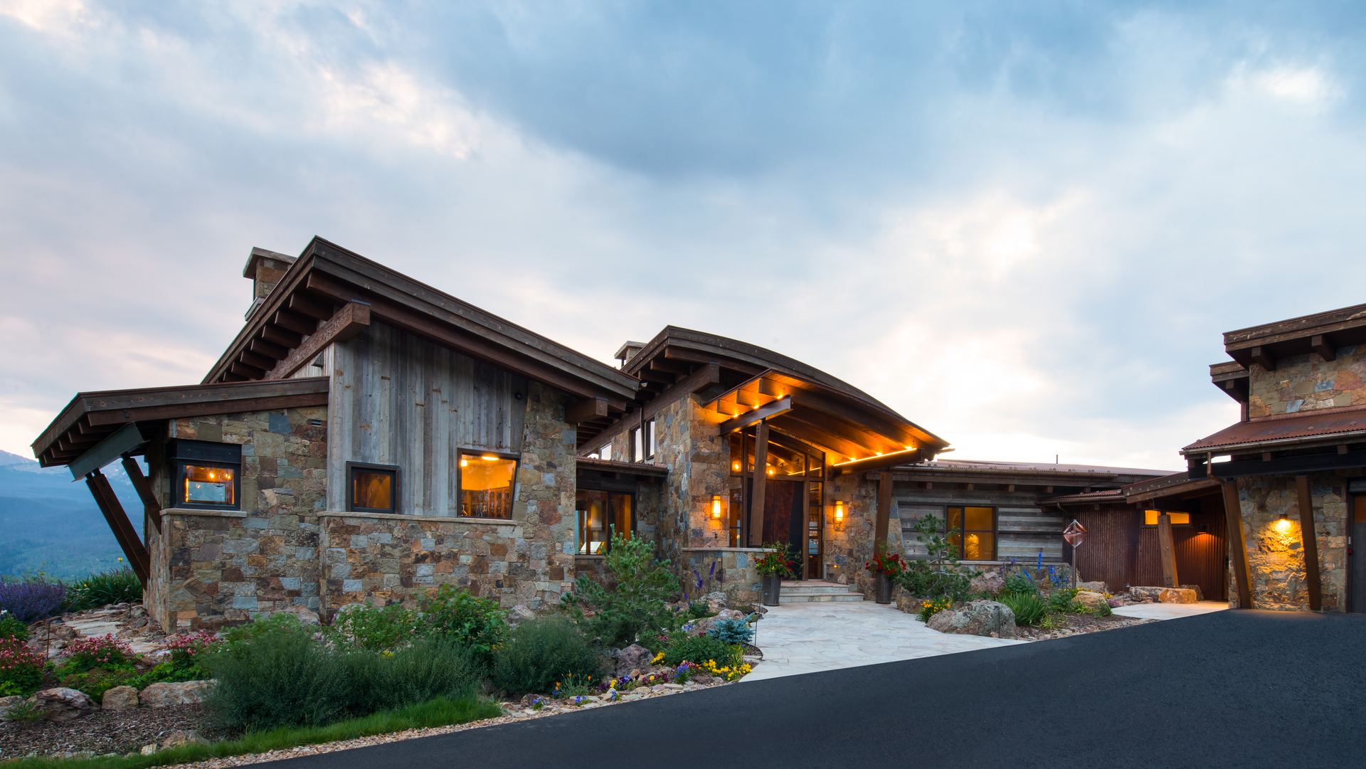 A large stone house with a wooden roof is sitting on top of a hill.