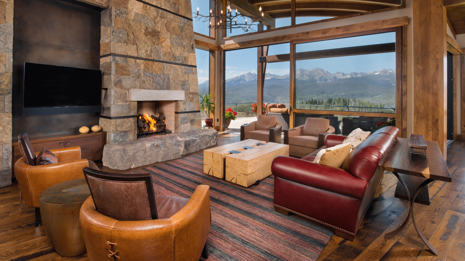 A living room with a fireplace , chairs , a couch and a television.