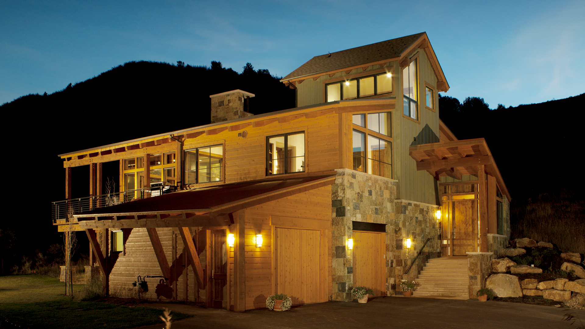 A large house with a lot of windows is lit up at night