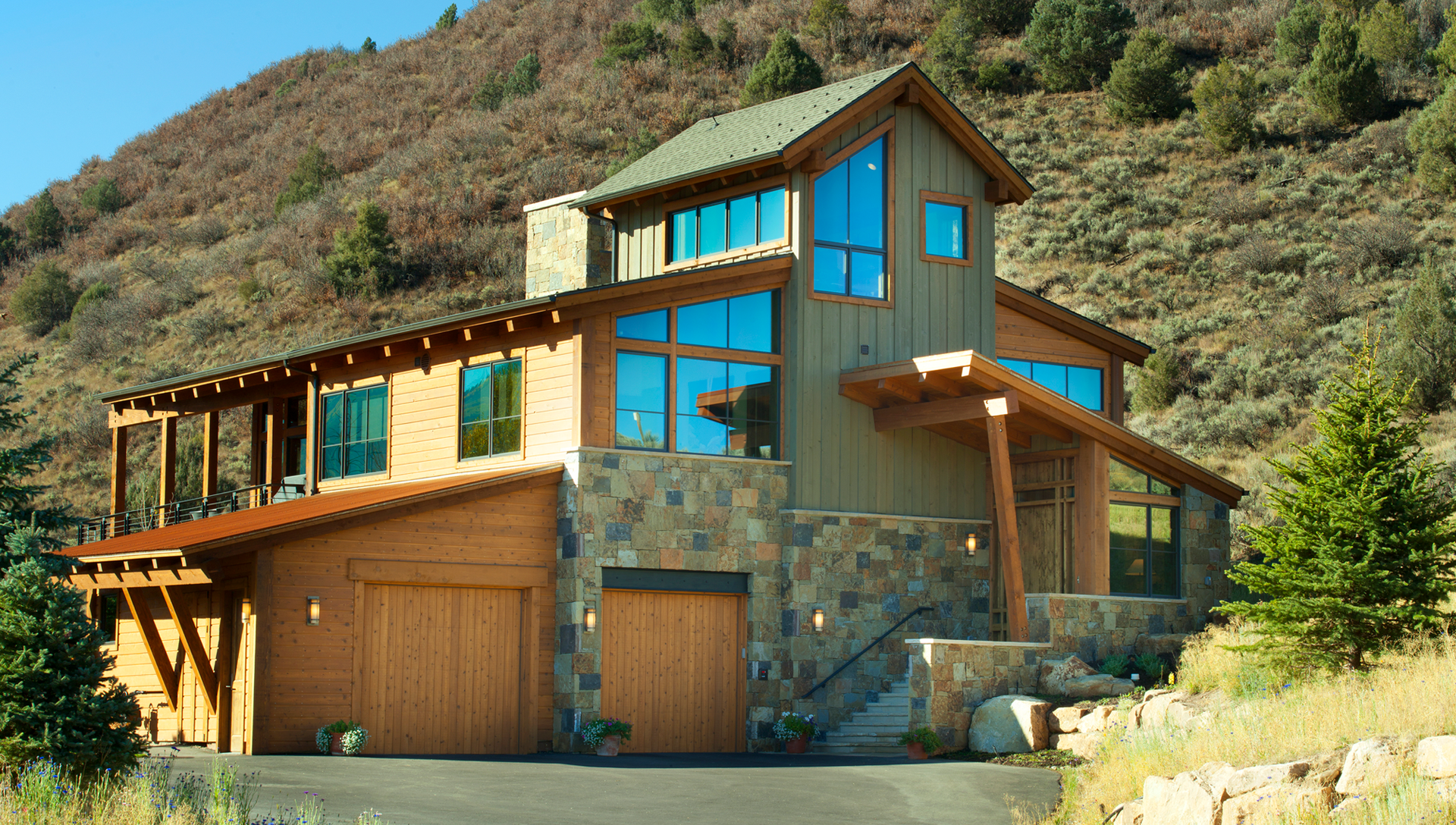 A large house with a lot of windows is sitting on top of a hill.