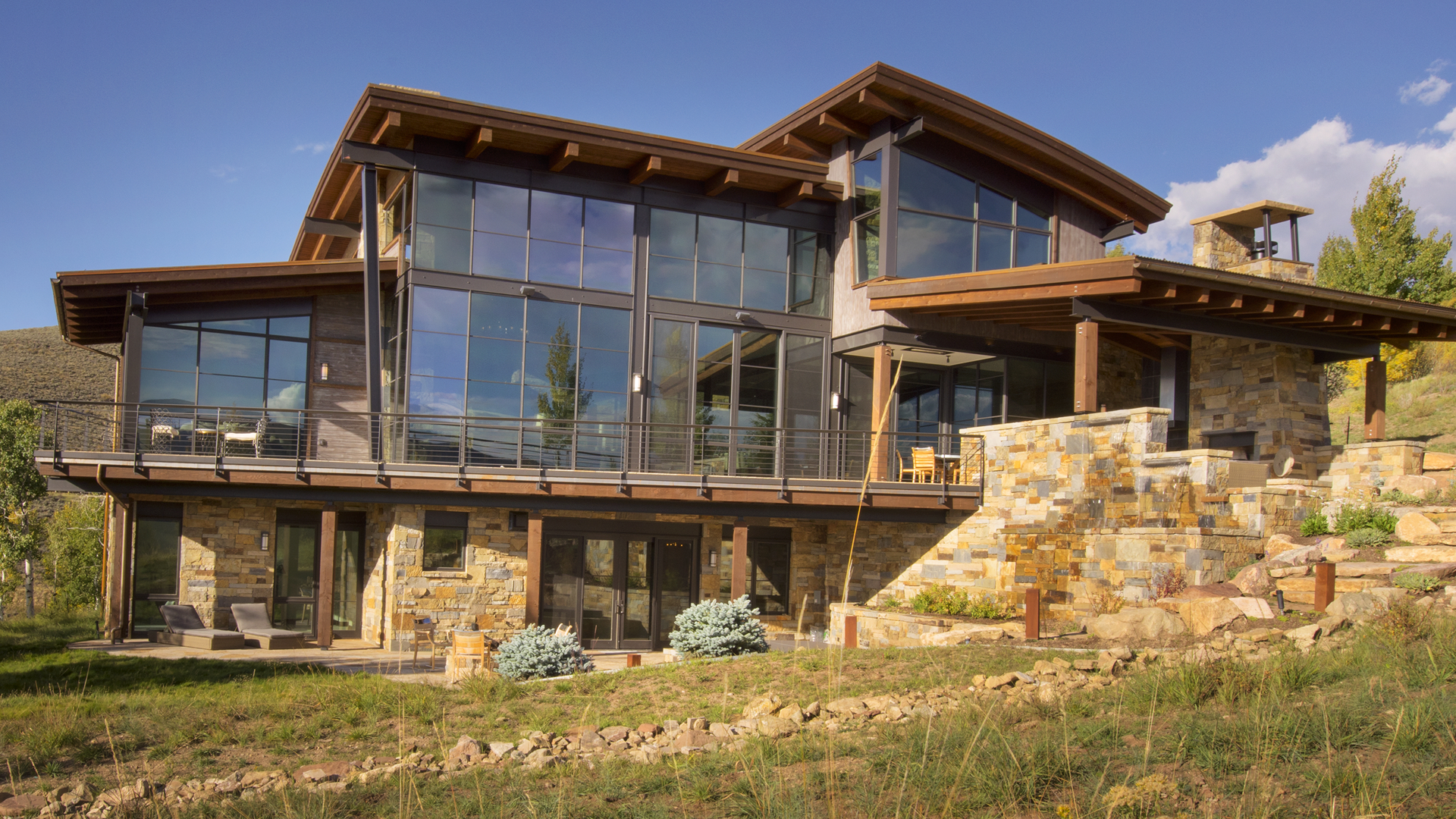 A large house with a lot of windows is sitting on top of a hill.