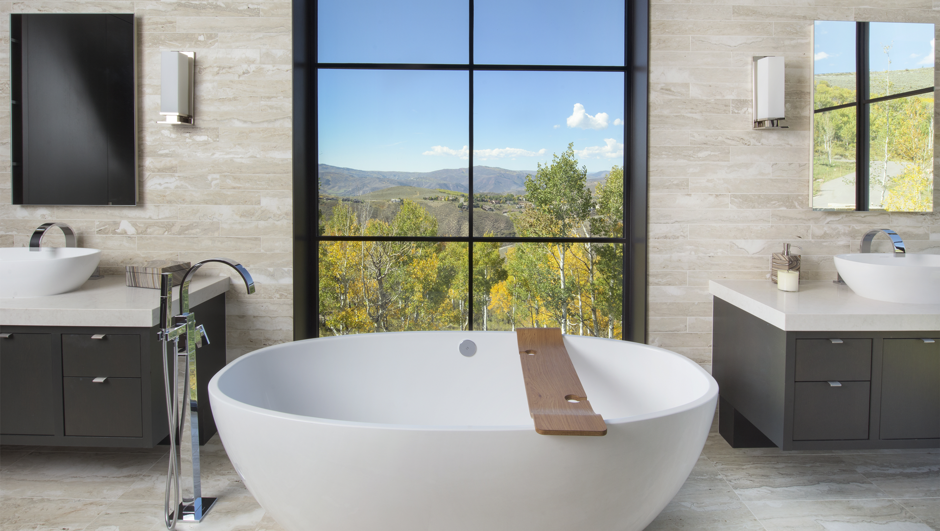 A bathroom with two sinks , a bathtub and a large window.