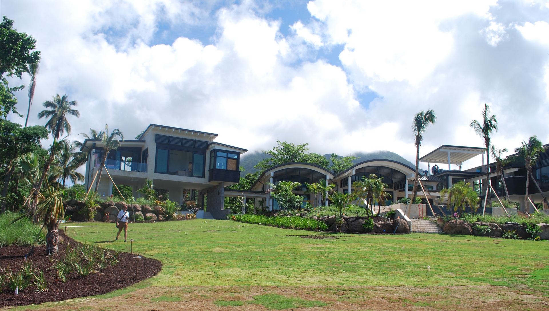 A large house sits in the middle of a lush green field