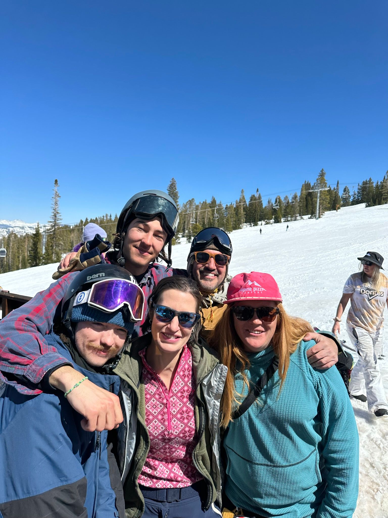 A group of people are posing for a picture on top of a snow covered mountain.