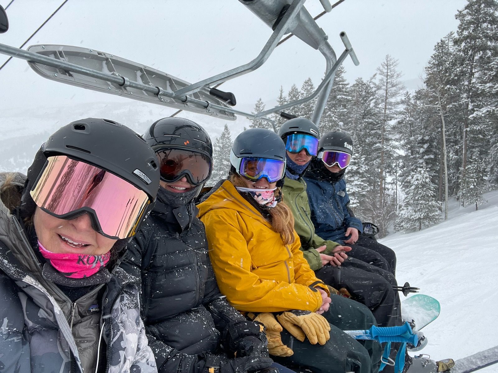 A group of people are riding a ski lift in the snow.
