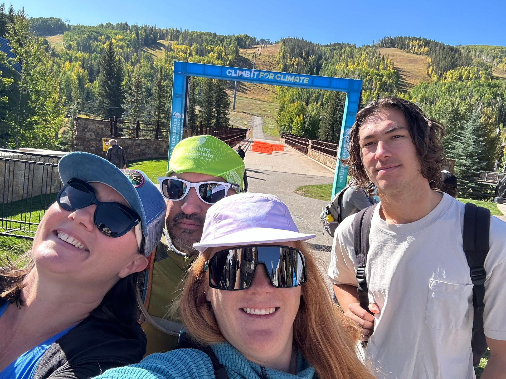 A group of people are posing for a picture in front of a mountain.