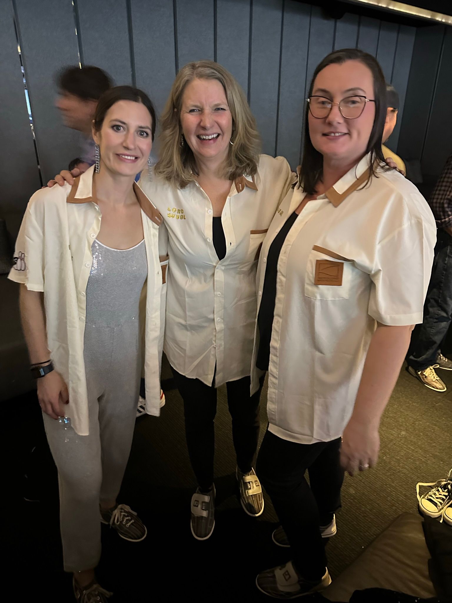 Three women are posing for a picture together in a room.