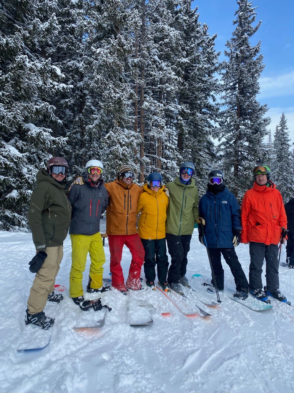 A group of people are posing for a picture in the snow.
