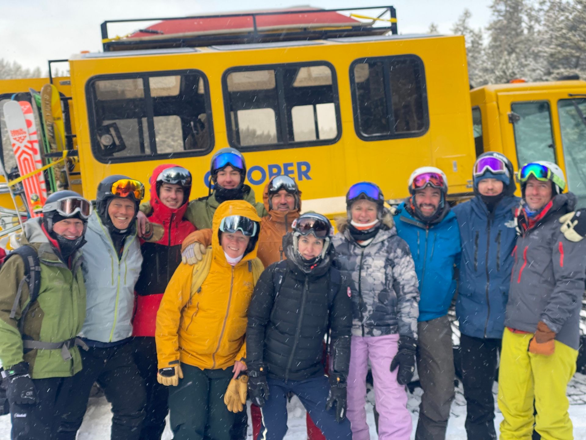 A group of people are posing for a picture in front of a yellow bus.