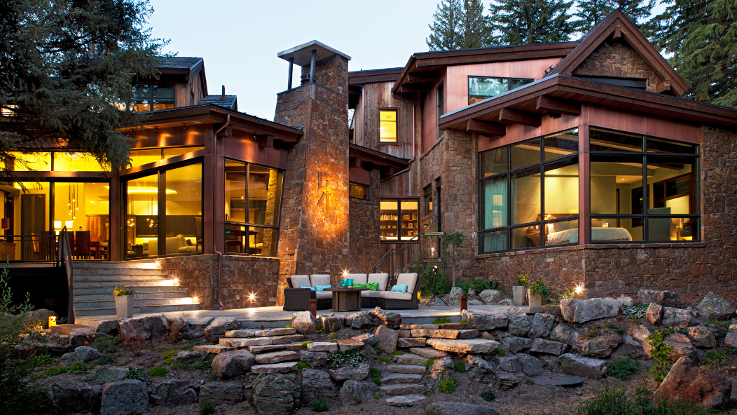 A large house with a lot of windows is lit up at night.