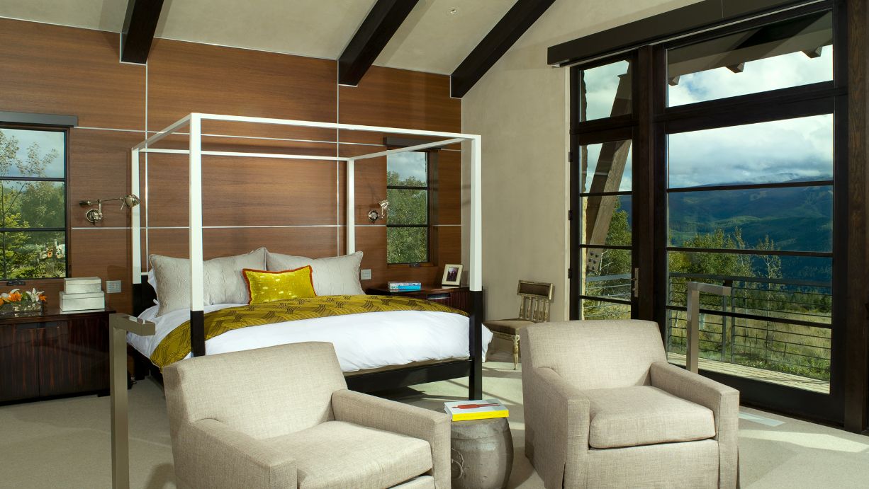 A bedroom with a canopy bed and two chairs