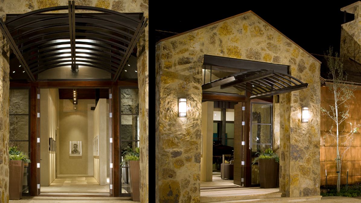 A large stone building with a canopy over the entrance at night.